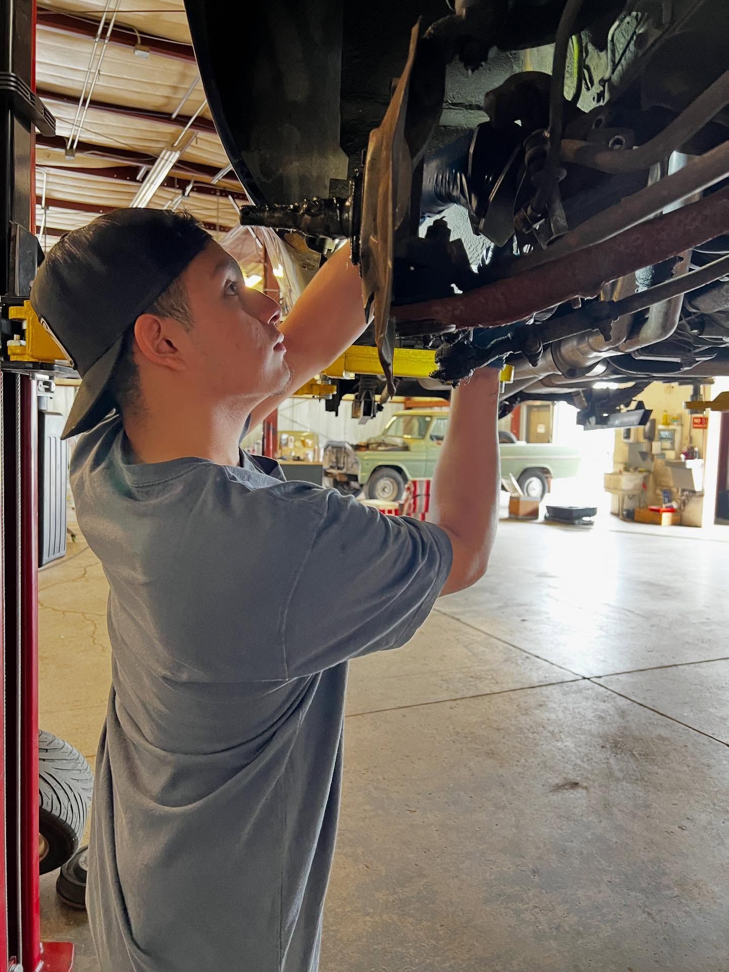 A Gearheadz technician working underneath a vehicle on the lift