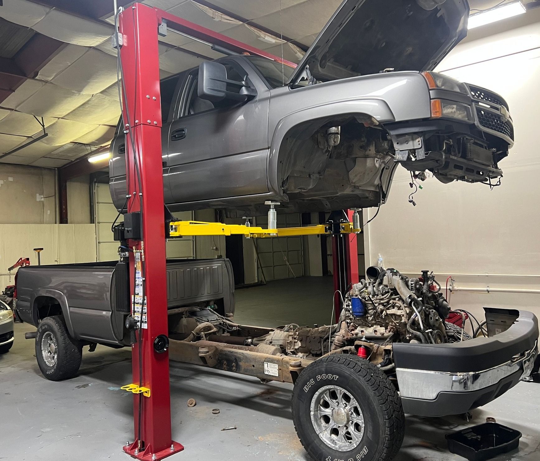 A truck raised on the lift mid-build with the diesel engine and frame exposed